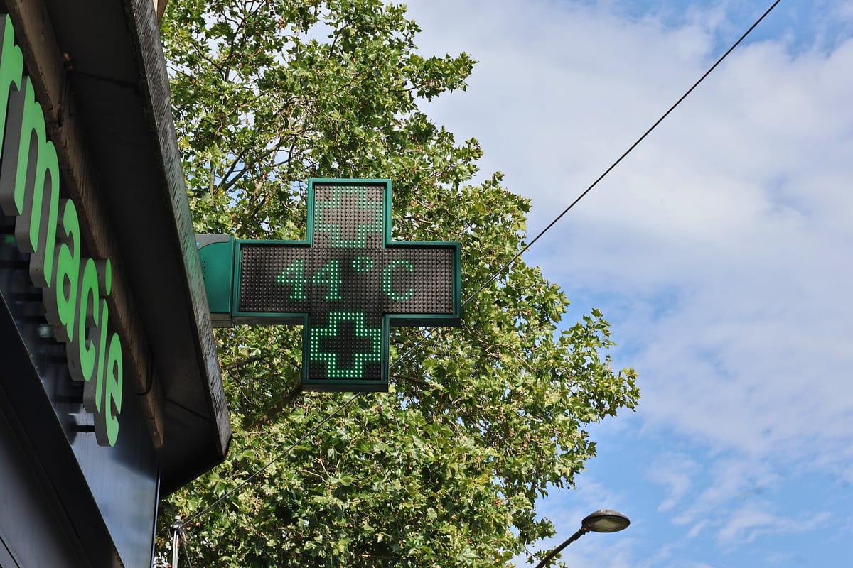 Green pharmacy cross sign on a street in Paris