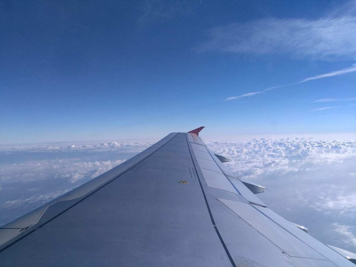 View from an aeroplane window over the wing and clouds